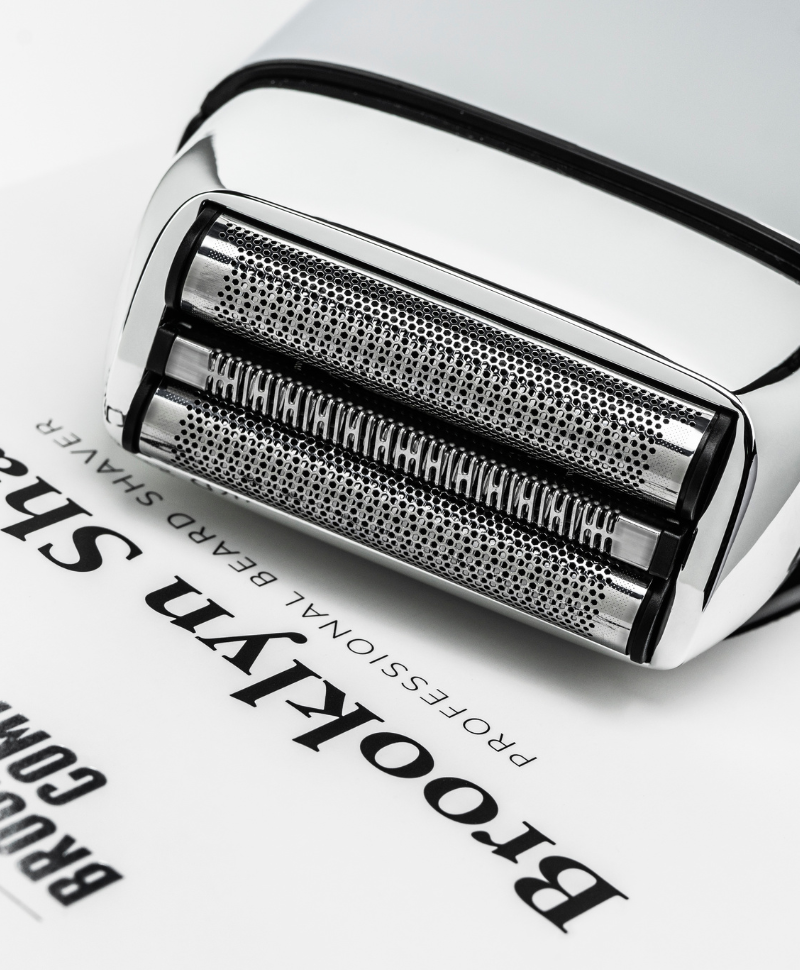 Detailaufnahme des Brooklyn Soap Company Shavers – elektrischer Rasierer mit präzisen Edelstahl-Scherköpfen auf Produktverpackung.