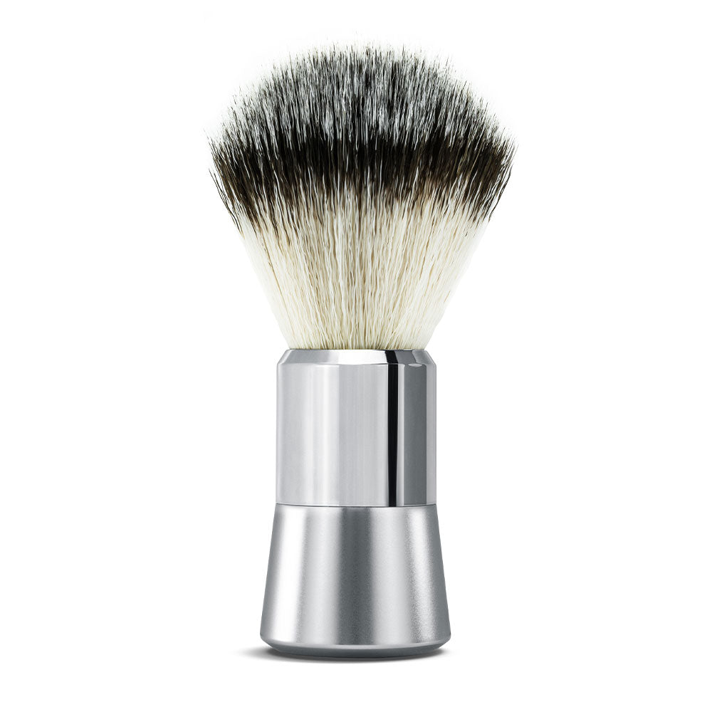 Der Rasierpinsel von der Brooklyn Soap Company ist die ideale Wahl für Männer, die eine besonders gründliche Rasur und perfekten Schaum suchen. Ausgestattet mit hochwertigen, veganen Borsten sorgt der Pinsel für einen dichten, cremigen Schaum, der die Barthaare optimal aufstellt und die Haut auf die Rasur vorbereitet. Der Griff aus robustem Messing und Aluminium liegt dank seines angenehmen Gewichts und der ergonomischen Form perfekt in der Hand. Ideal für die klassische Nassrasur mit Rasierseife.