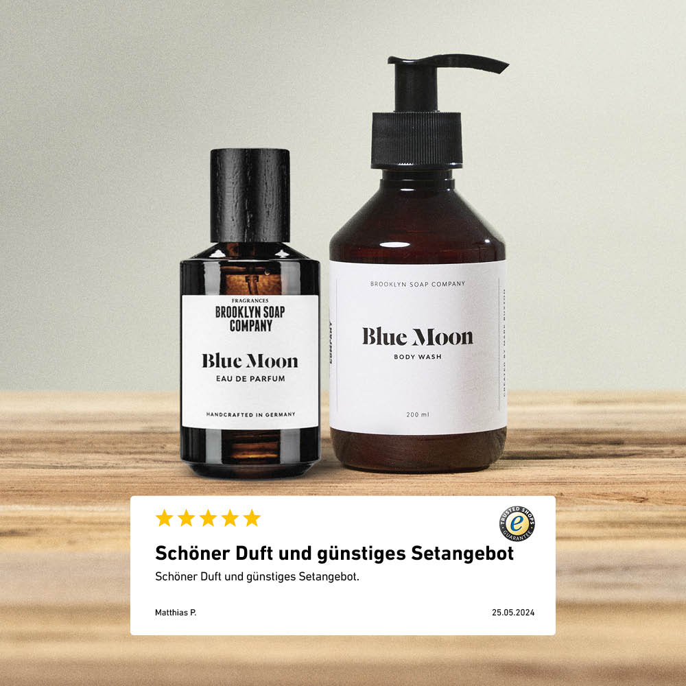 Brooklyn Soap Company Blue Moon Eau de Parfum und Body Wash auf einem Holztisch mit Kundenbewertung, die Duft und günstiges Setangebot lobt.